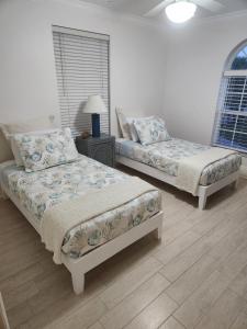 a bedroom with two beds and a table with a lamp at Turtle Caye in Sanibel
