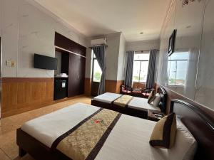 a hotel room with two beds and a television at SEAMOON Hotel in Rạch Giá