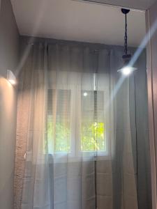 a window with white curtains in a room at Julia's House in Mikros Gialos +17 photos