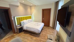a bedroom with a bed and a flat screen tv at Hôtel Corner King in Skikda