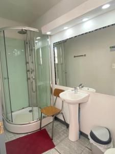 a bathroom with a sink and a shower at Hostal Cochrane in Valdivia