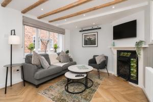 a living room with a couch and a fireplace at Lion Cottage - Dog-Friendly 3-Bed in Heart of Holt in Holt