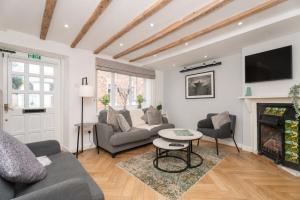 a living room with a couch and a fireplace at Lion Cottage - Dog-Friendly 3-Bed in Heart of Holt in Holt