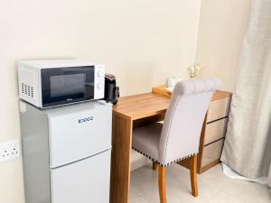 a microwave sitting on top of a desk with a refrigerator at Rugira Guest House in Vosburg