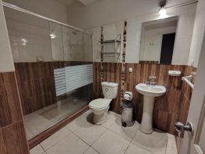 a bathroom with a toilet and a shower and a sink at Hotel Safari in Iquitos +32 photos