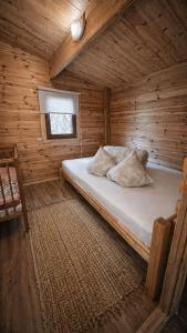 a bedroom with a bed in a wooden cabin at Camping Bušas in Saulkrasti