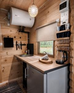 a kitchen with wooden walls and a counter with a sink at Camping Bušas in Saulkrasti