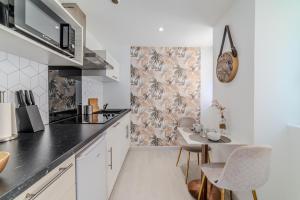 a kitchen with white cabinets and a table and chairs at LOVE ROOM - Amour Chic et Intime in Montbrison
