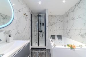 a white bathroom with a shower and a sink at LOVE ROOM - Amour Chic et Intime in Montbrison