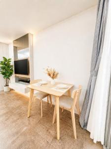a dining room with a table and a tv at Green View Condo in Kathu