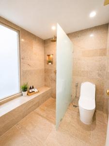 a bathroom with a toilet and a tub and a window at Green View Condo in Kathu