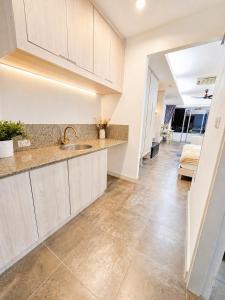 a kitchen with white cabinets and a tile floor at Green View Condo in Kathu +5 photos