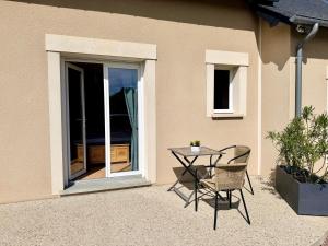 a table and chairs sitting outside of a house at La brèche fleurie in Cricquebœuf