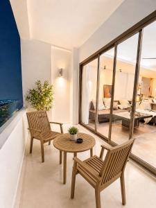 a living room with two chairs and a table and a bedroom at Green View Condo in Kathu