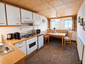 a kitchen with white appliances and a table in it at Beim Talschuster in Scheffau am Wilden Kaiser