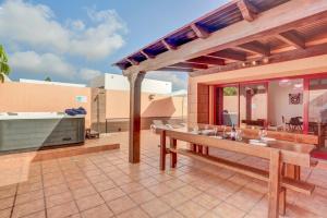 an outdoor patio with a table and a kitchen at Villa Malva in Corralejo