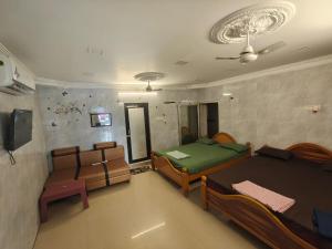 a room with two beds and a table and chairs at Kanchi grace cottage in Kanchipuram