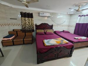 a bedroom with two beds and a couch at Kanchi grace cottage in Kanchipuram