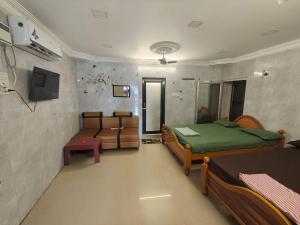 a room with two beds and a tv in it at Kanchi grace cottage in Kanchipuram +6 photos