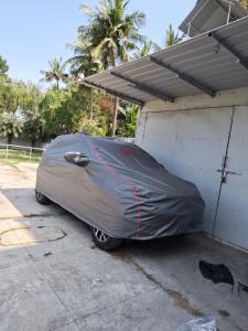 a car covered in a tarp parked in a garage at Kanchi grace cottage in Kanchipuram