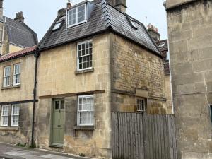 an old stone building with a green door at Daylily Cottage - Two Bedroom Georgian Cottage in Central Bath in Bath