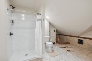 a white bathroom with a toilet and a shower at The Cooperhouse in Independence