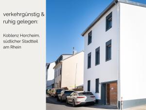 a row of cars parked in a parking lot next to buildings at Zeitwohnstudios work & stay - modern, vollausgestattet für Selbstversorger in Koblenz