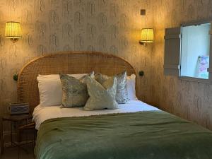 a bedroom with a bed with pillows on it at Daylily Cottage - Two Bedroom Georgian Cottage in Central Bath in Bath