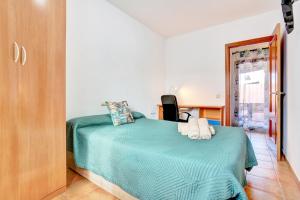 a bedroom with a bed with a green blanket at Villa Malva in Corralejo