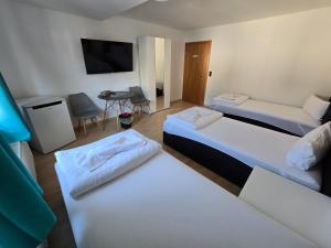 a hotel room with three beds and a flat screen tv at RS Zimmervermietung in Zülpich