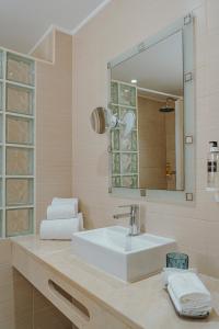 a bathroom with a white sink and a mirror at Apartamentos Borda D´Agua in Albufeira +63 photos