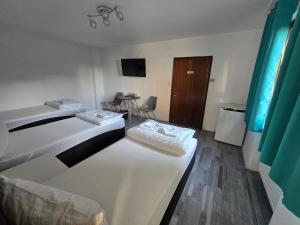 a hotel room with two beds and a television at RS Zimmervermietung in Zülpich +5 photos
