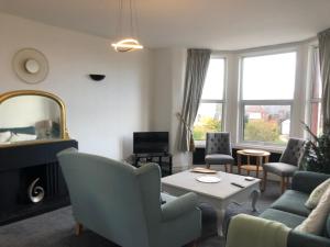 a living room with a couch and chairs and a table at Apartments at 145 in Southport