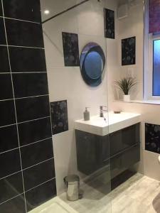 a bathroom with a sink and a mirror at Apartments at 145 in Southport +20 photos
