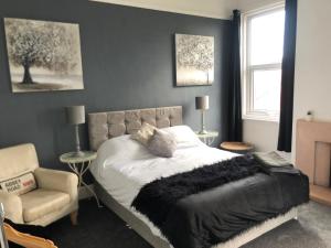 a bedroom with a bed and a chair at Apartments at 145 in Southport
