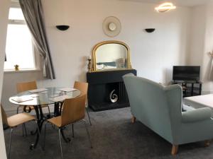 a living room with a table and chairs and a mirror at Apartments at 145 in Southport