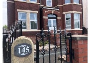 a black gate with a sign in front of a house at Apartments at 145 in Southport