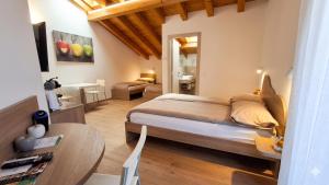 a bedroom with a bed and a table in a room at Agritur Clementi in Nave San Rocco