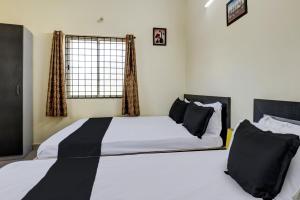 a bedroom with a large bed with black pillows at Hotel O Indian Residency, Near Adams Academy, Kadugodi in Bangalore