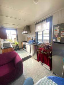 a kitchen with a stove and a couch in a room at Hostal Cochrane in Valdivia