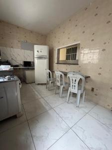 a kitchen with a table and chairs and a refrigerator at Jampa Pousada Sb in João Pessoa