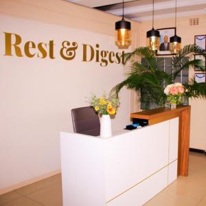 a reception desk with a register and disrespect sign on the wall at Rest & Digest in Serowe