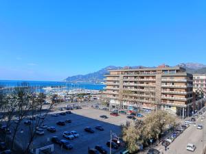 a large apartment building with a parking lot and the ocean at Room with a view in Salerno