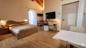 a bedroom with a bed and a desk and a table at Agritur Clementi in Nave San Rocco