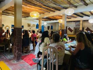 a group of people sitting at tables in a restaurant at Merzouga Hotel Activities in Merzouga