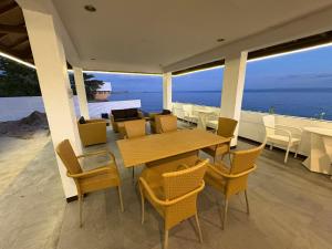 a patio with a table and chairs and the ocean at Hostel Asilda in San Fernando