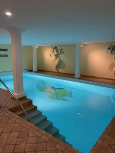 a large swimming pool with stairs and a swimming pool at Restaurant Hotel Merlet in Schoorl