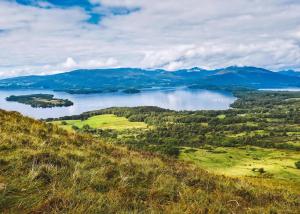 a view of a lake with mountains in the distance at Benview Lodges in Kemnay