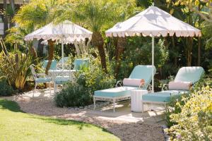 a group of chairs and an umbrella in a garden at Pavilion Hotel in Avalon