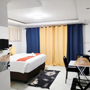 a bedroom with a bed and blue and yellow curtains at Rest & Digest in Serowe +47 photos